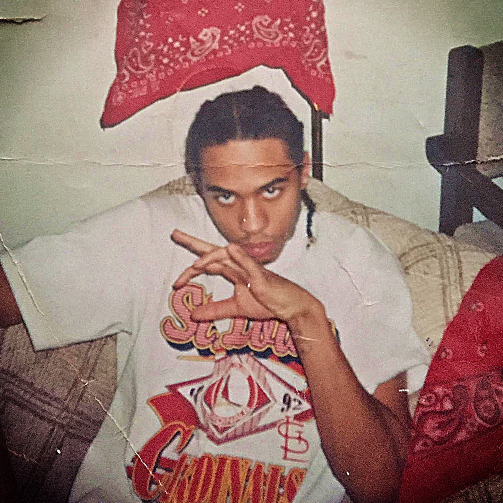 Photo of Terrance, age 17, soon after being “put on” the hood as an official Blood, flashing gang signs, circa 1993.